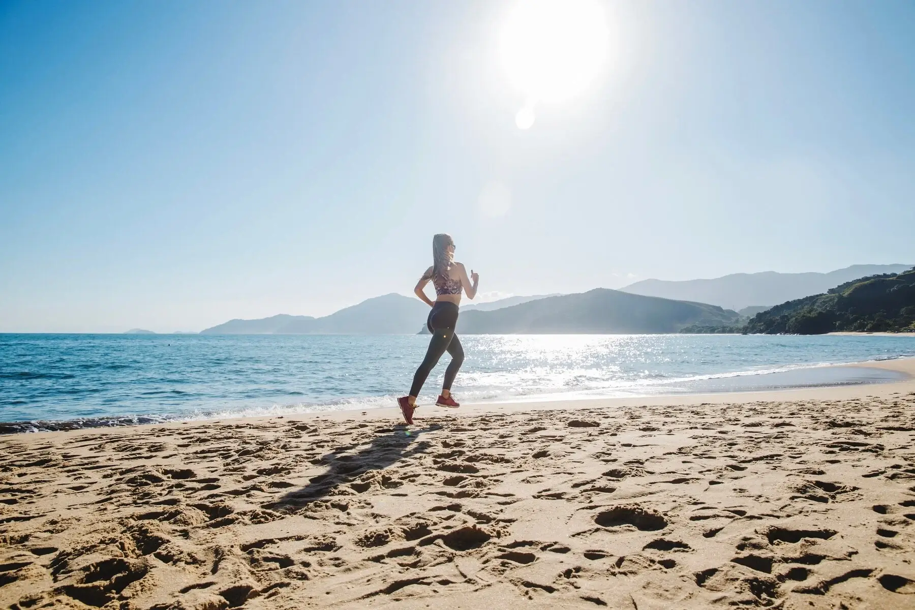 pessoa correndo na areia locais para praticar atividade fisica ao ar livre na praia do campeche em florianopolis